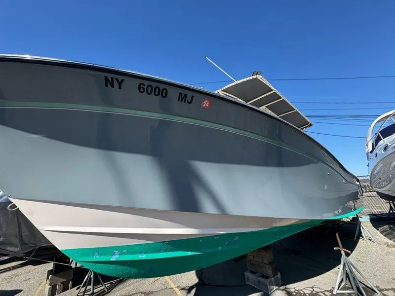 Slide: The Image of 2000 Grady-White Bimini 306 boat on dry dock, side view, clear sky background. - 28