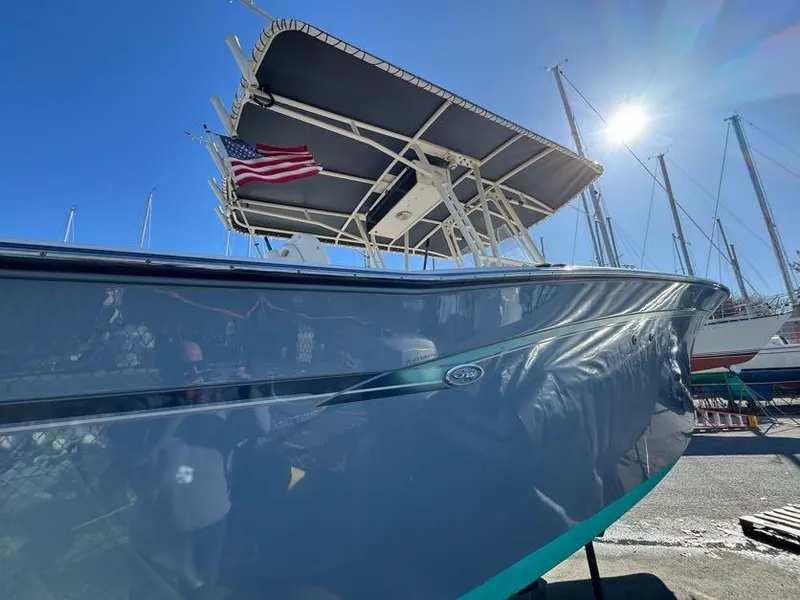Slide: The Image of 2000 Grady-White Bimini 306 boat with American flag, docked under clear blue sky. - 29