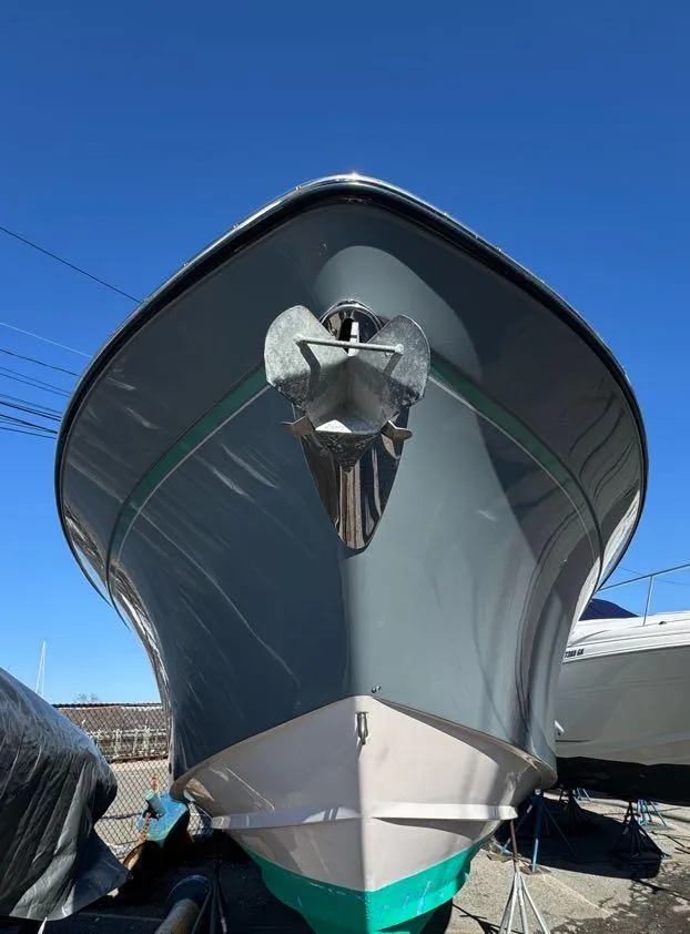 Slide: The Image of 2000 Grady-White Bimini 306 boat, front view, anchored, clear blue sky background. - 31