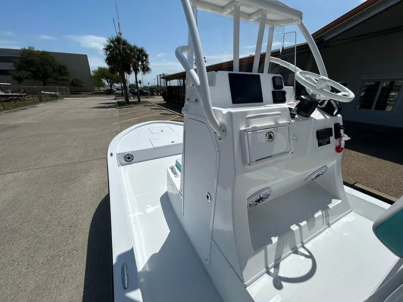 Slide: The Image of 2025 Shallow Sport 24 Sport boat with sleek console design in a sunny outdoor setting. - 10