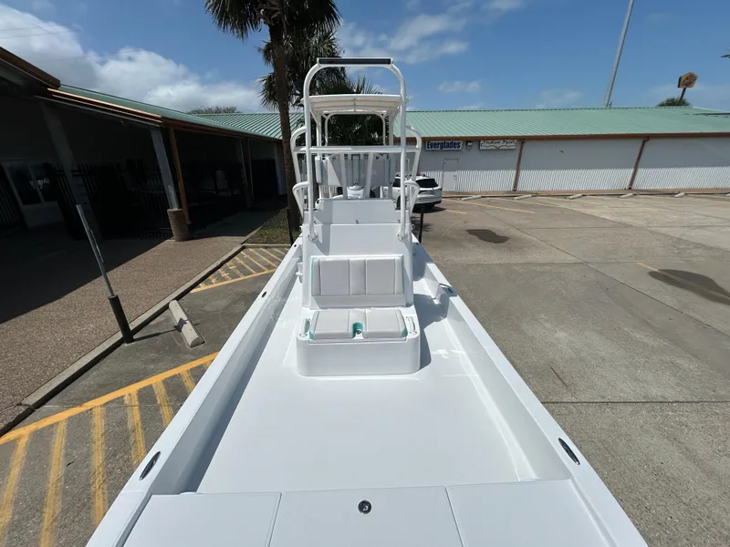 Slide: The Image of 2025 Shallow Sport 24 Sport boat, docked, with clear sky background. - 14