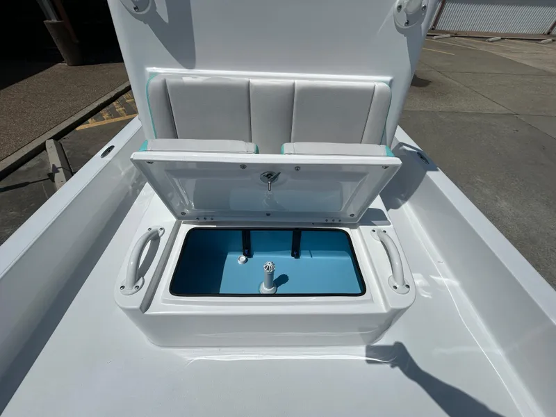 Slide: The Image of 2025 Shallow Sport 24 Sport boat with open storage compartment and cushioned seating. - 15