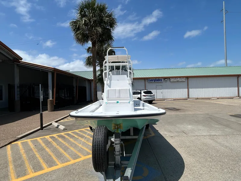 Slide: The Image of 2025 Shallow Sport 24 Sport boat on trailer in sunny parking lot. - 2