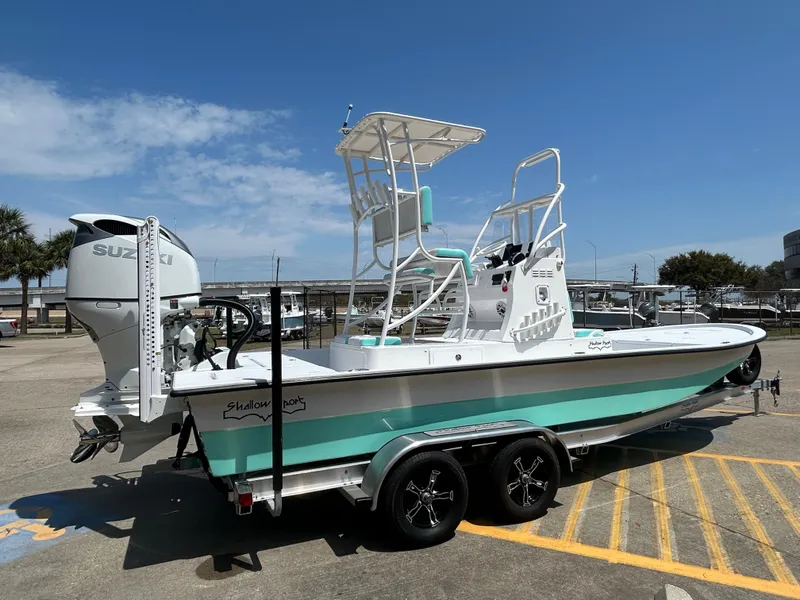 Slide: The Image of 2025 Shallow Sport 24 Sport boat on trailer, featuring a Suzuki outboard motor. - 4