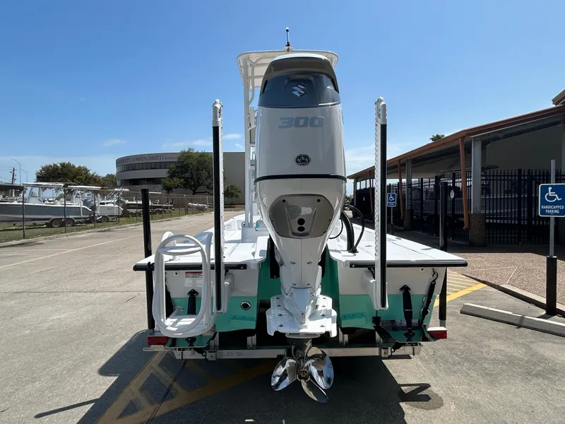 Slide: The Image of 2025 Shallow Sport 24 Sport boat with powerful outboard motor, parked in a sunny lot. - 5