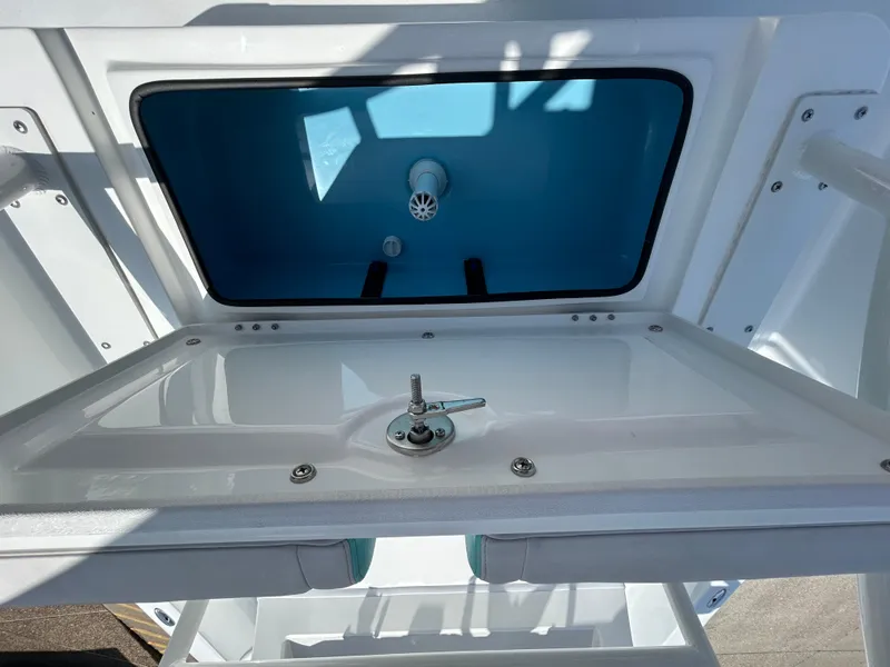 Slide: The Image of 2025 Shallow Sport 24 Sport boat storage compartment with open lid, showcasing interior design. - 6