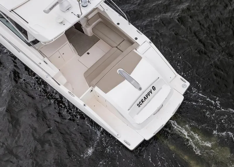 Slide: The Image of 2015 Pursuit SC 365i Sport Coupe on water, aerial view, featuring spacious deck. - 12