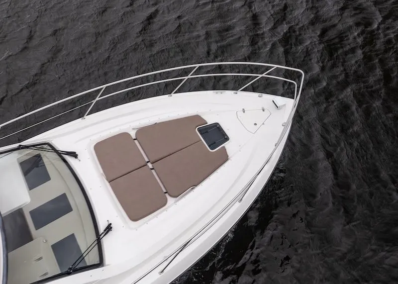 Slide: The Image of 2015 Pursuit SC 365i Sport Coupe boat deck with sun pads on water. - 13