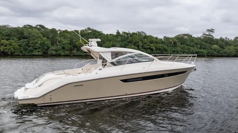 Slide: The Image of 2015 Pursuit SC 365i Sport Coupe cruising on a river with lush green backdrop. - 15