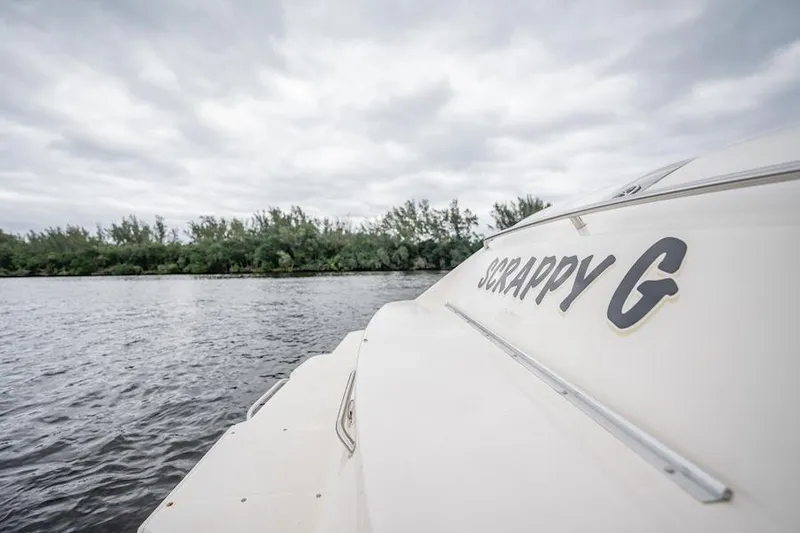 Slide: The Image of 2015 Pursuit SC 365i Sport Coupe on a cloudy day by the water. - 22