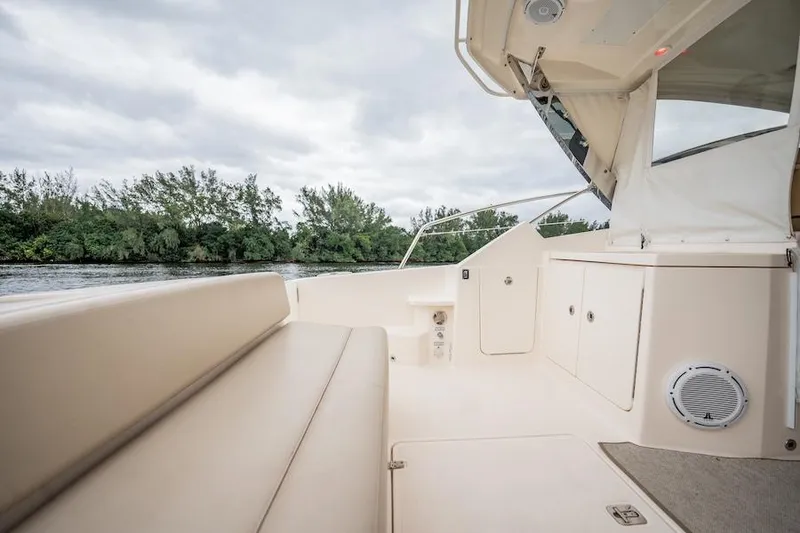 Slide: The Image of 2015 Pursuit SC 365i Sport Coupe interior with seating, cabinets, and water view. - 25