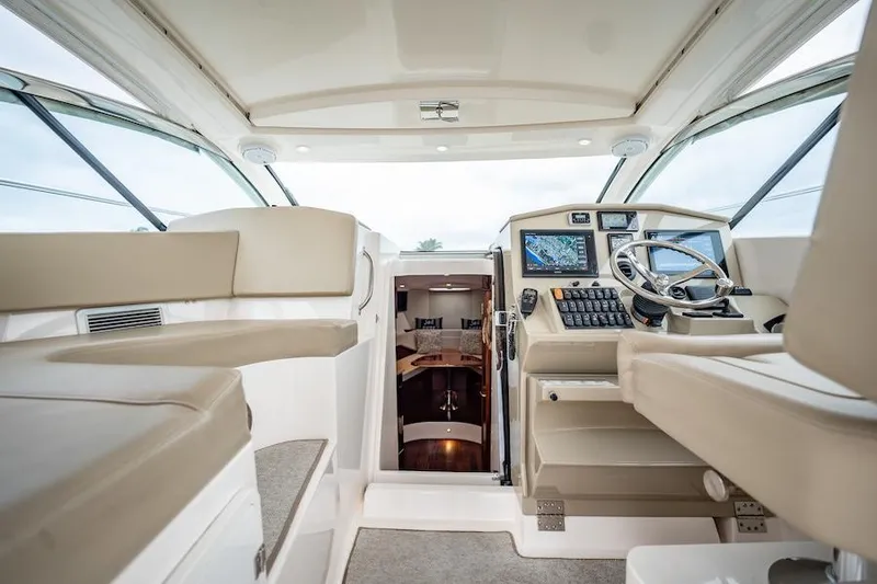 Slide: The Image of 2015 Pursuit SC 365i Sport Coupe interior with helm and seating area. - 31