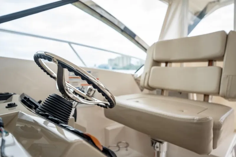 Slide: The Image of 2015 Pursuit SC 365i Sport Coupe helm with beige seating and steering wheel. - 35
