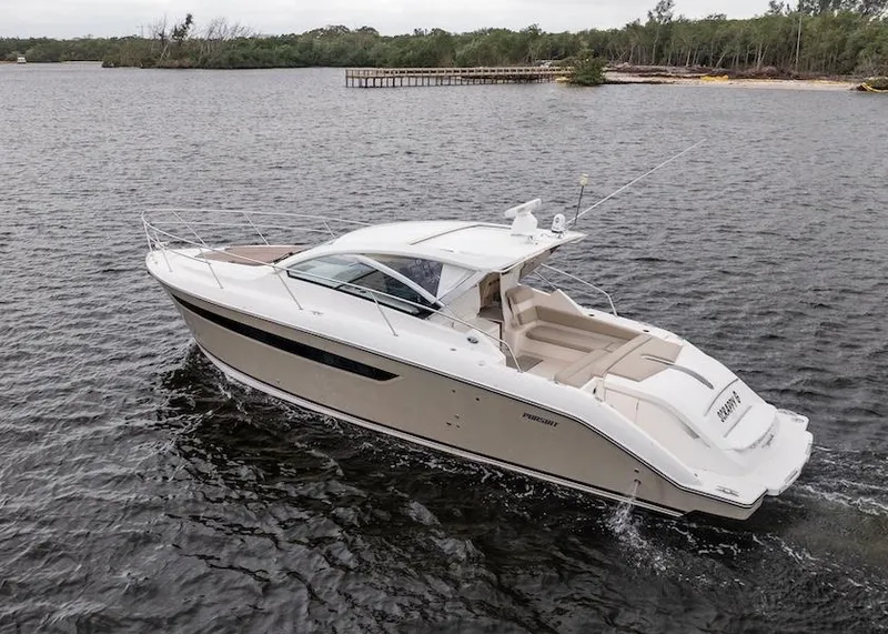 Slide: The Image of 2015 Pursuit SC 365i Sport Coupe cruising on a calm lake with lush shoreline. - 6
