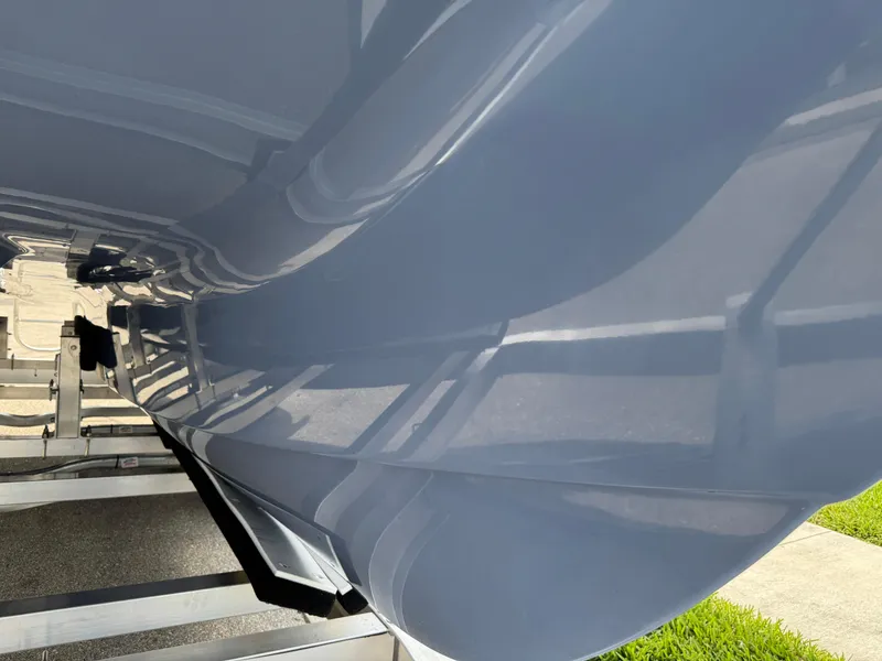 Slide: The Image of 2022 World Cat 230 SD boat hull on trailer, showcasing sleek design and glossy finish. - 11