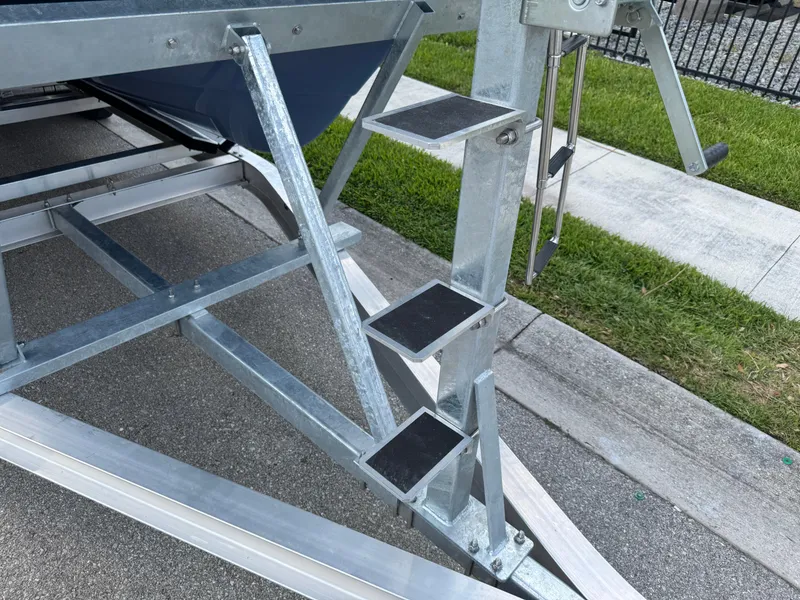 Slide: The Image of Metal steps on a 2022 World Cat 230 SD boat trailer, parked on pavement. - 15