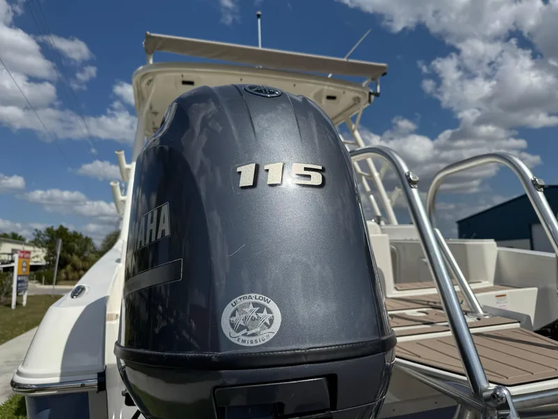 Slide: The Image of 2022 World Cat 230 SD boat with Yamaha 115 engine, under a partly cloudy sky. - 16