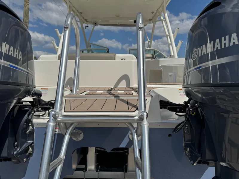 Slide: The Image of 2022 World Cat 230 SD boat with Yamaha engines and ladder, under a clear blue sky. - 19