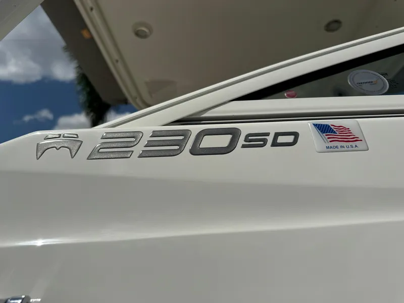 Slide: The Image of 2022 World Cat 230 SD boat emblem with American flag sticker, sunny day. - 23