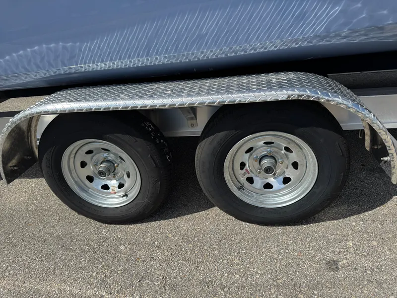 Slide: The Image of Trailer wheels of a 2022 World Cat 230 SD boat on pavement. - 24