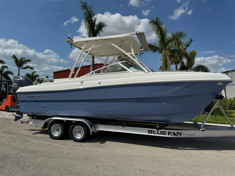 Slide: The Image of 2022 World Cat 230 SD boat on trailer, parked outdoors with palm trees in background. - 3