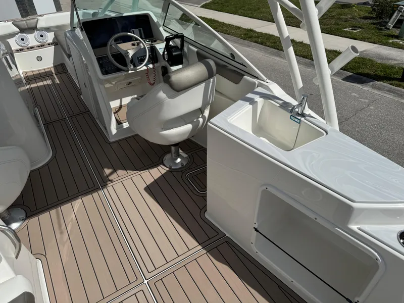 Slide: The Image of 2022 World Cat 230 SD boat interior with helm, seating, and sink. - 38