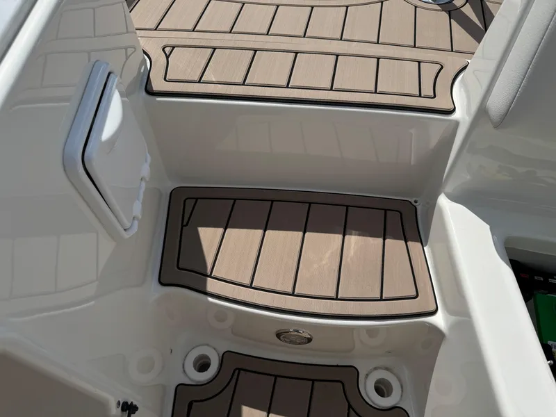 Slide: The Image of 2022 World Cat 230 SD boat deck with non-slip flooring and storage compartment. - 47