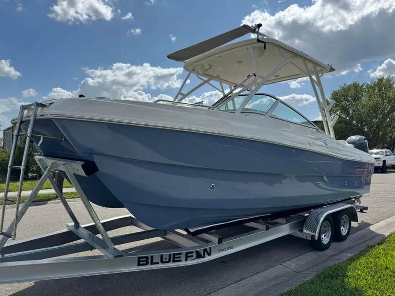 Slide: The Image of 2022 World Cat 230 SD boat on Blue Fin trailer under a sunny sky. - 9