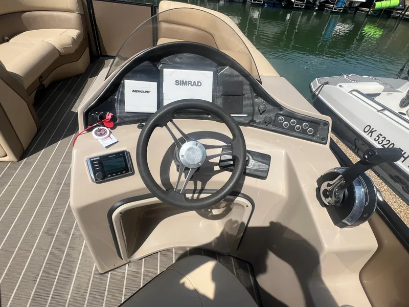 Slide: The Image of 2019 Bentley Pontoons 223 dashboard with steering wheel and control panel by the water. - 11