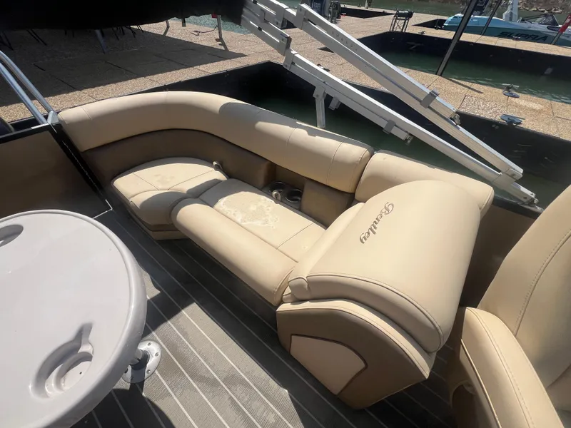 Slide: The Image of 2019 Bentley Pontoons 223 with beige seating and a round table on deck. - 21