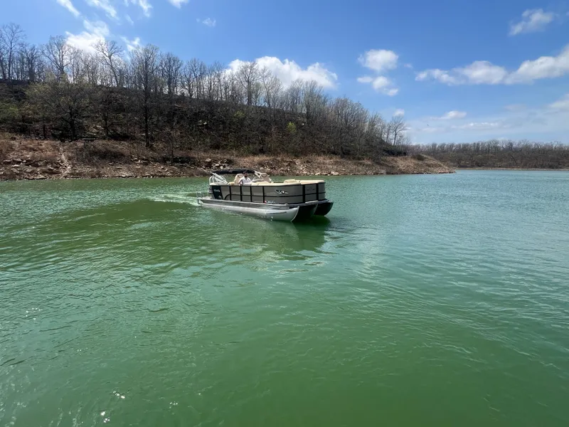 Slide: The Image of 2019 Bentley Pontoons 223 on a serene lake under a clear blue sky. - 25