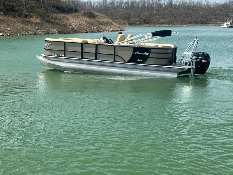 Slide: The Image of 2019 Bentley Pontoons 223 on a serene lake with wooded shoreline. - 7
