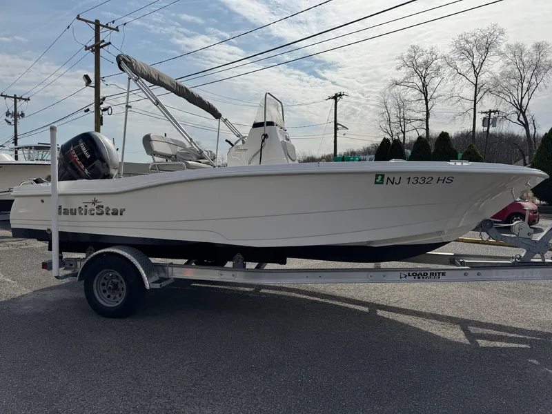 Slide: The Image of 2023 NauticStar 191 Hybrid boat on trailer, parked outdoors. - 5