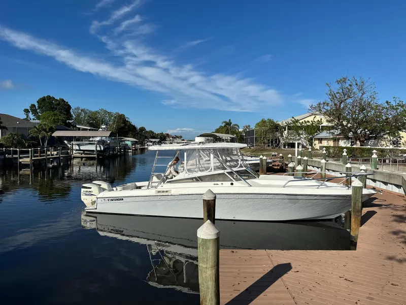 Slide: The Image of 2001 Contender 35 Side Console boat docked in a serene canal setting. - 3