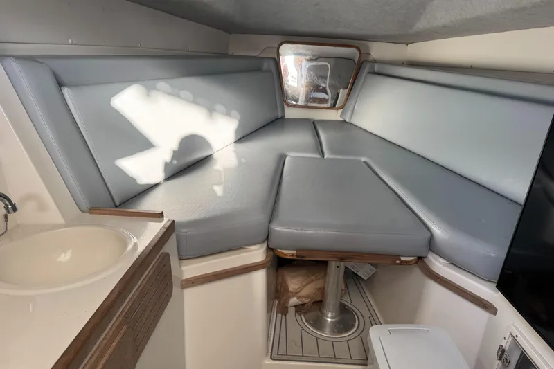 Slide: The Image of 2001 Contender 35 Side Console cabin interior with gray seating and compact sink. - 9