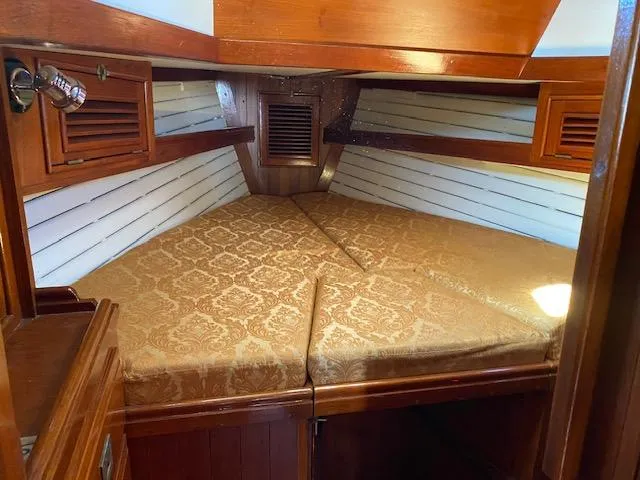 Slide: The Image of Cozy cabin interior of 1988 Shannon 43 sailboat with elegant wood finish and patterned bedding. - 5