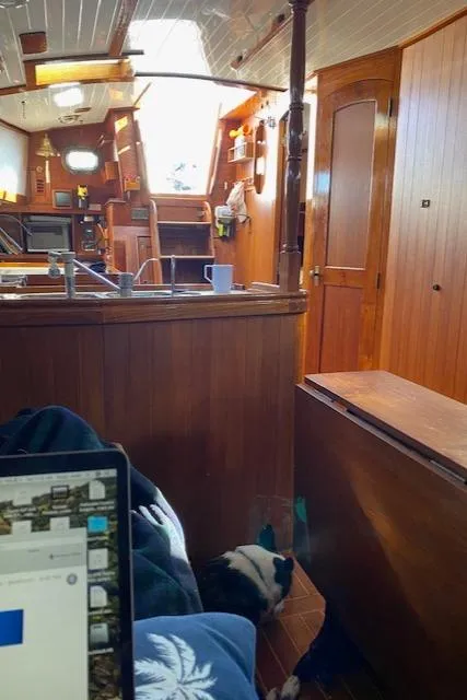 Slide: The Image of Interior of a 1988 Shannon 43 sailboat with wooden furnishings and a cozy atmosphere. - 6