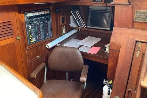 Slide: The Image of Navigation station inside 1988 Shannon 43 sailboat, featuring wooden interior and control panel. - 7