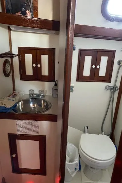 Slide: The Image of 1988 Shannon 43 yacht bathroom with sink, toilet, and wooden cabinets. - 9
