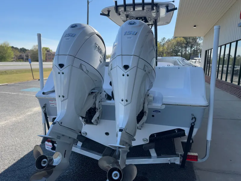 Slide: The Image of 2024 Sportsman Open 252 Center Console with dual outboard engines, parked outdoors. - 8