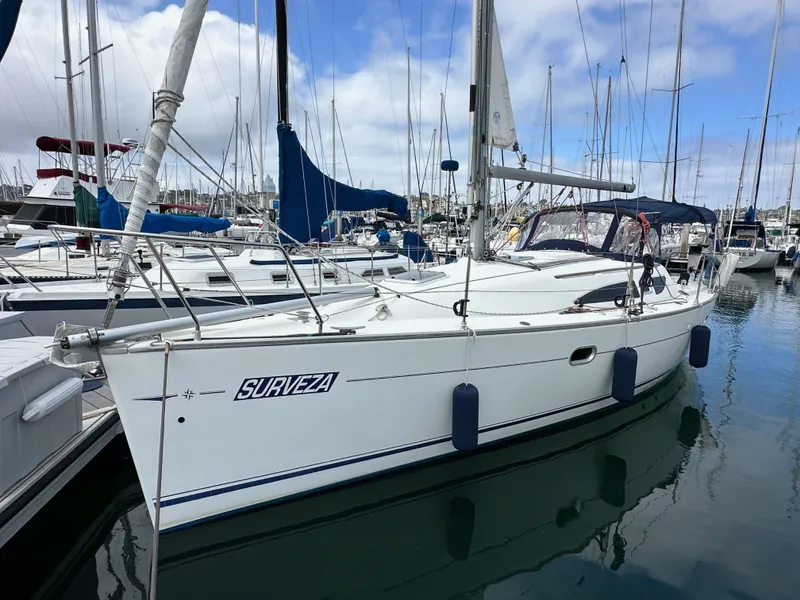 Slide: The Image of 2003 Jeanneau Sun Odyssey 32 sailboat docked in marina, clear sky background. - 0