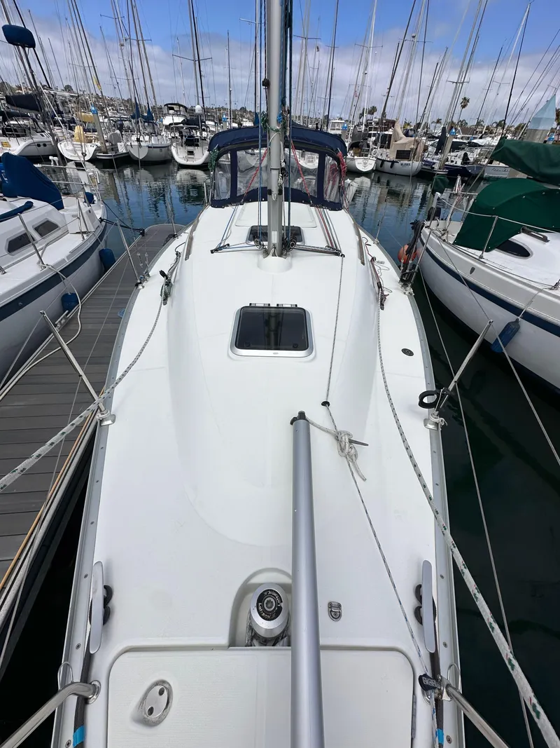 Slide: The Image of 2003 Jeanneau Sun Odyssey 32 sailboat docked in a marina, surrounded by other boats. - 18