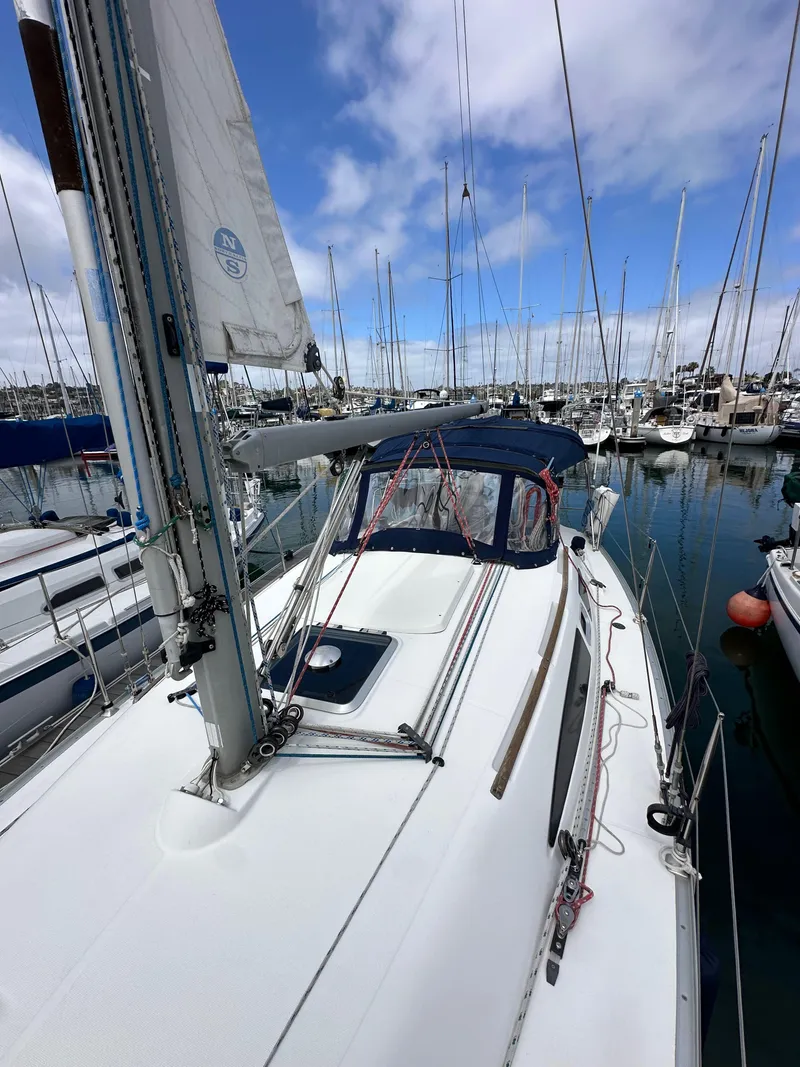 Slide: The Image of 2003 Jeanneau Sun Odyssey 32 sailboat docked in a marina under a partly cloudy sky. - 20