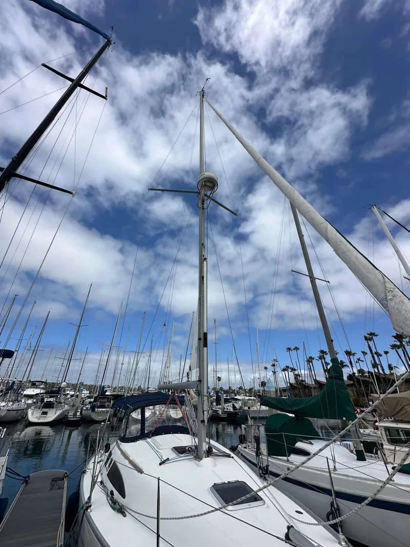Slide: The Image of 2003 Jeanneau Sun Odyssey 32 sailboat docked in a marina under a partly cloudy sky. - 3