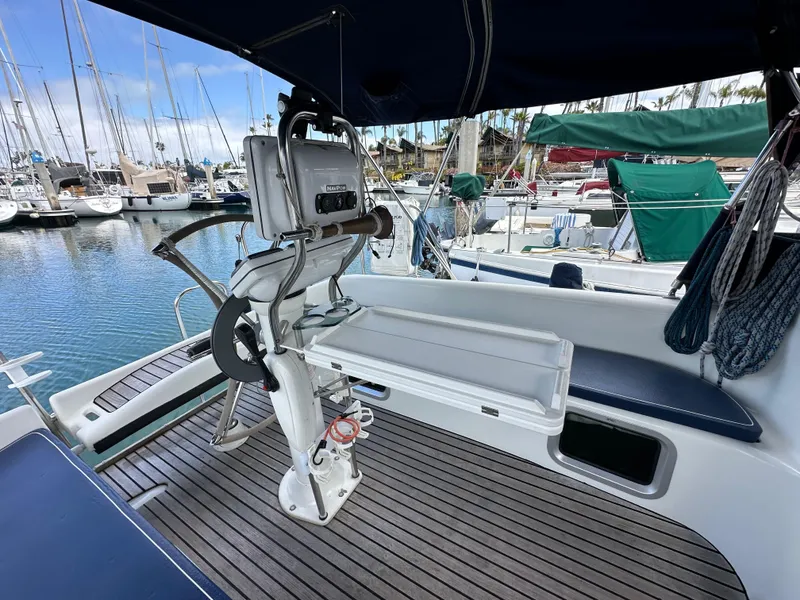 Slide: The Image of 2003 Jeanneau Sun Odyssey 32 sailboat cockpit with wooden deck and marina view. - 34