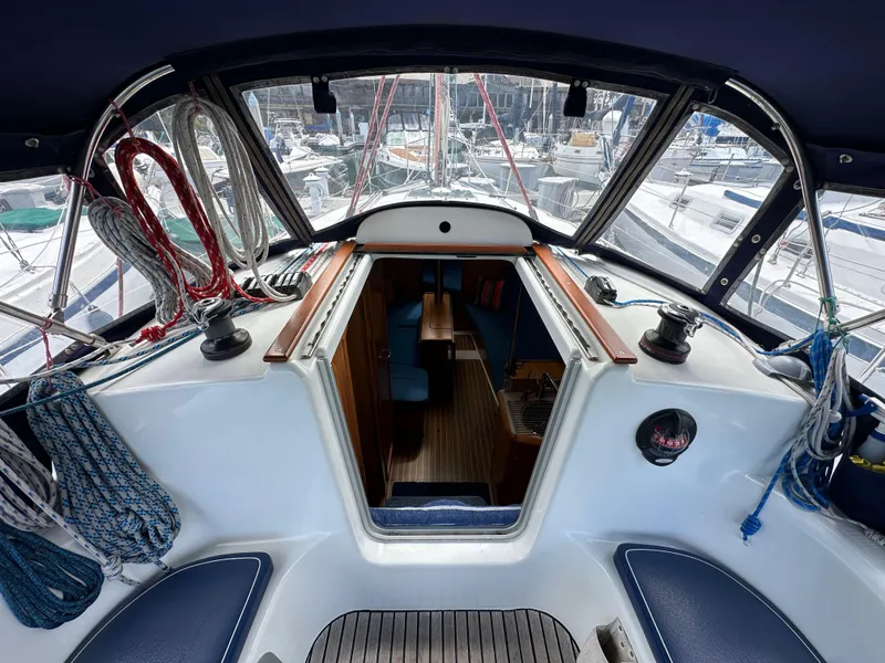 Slide: The Image of Cockpit view of 2003 Jeanneau Sun Odyssey 32 sailboat, showcasing interior and marina surroundings. - 38