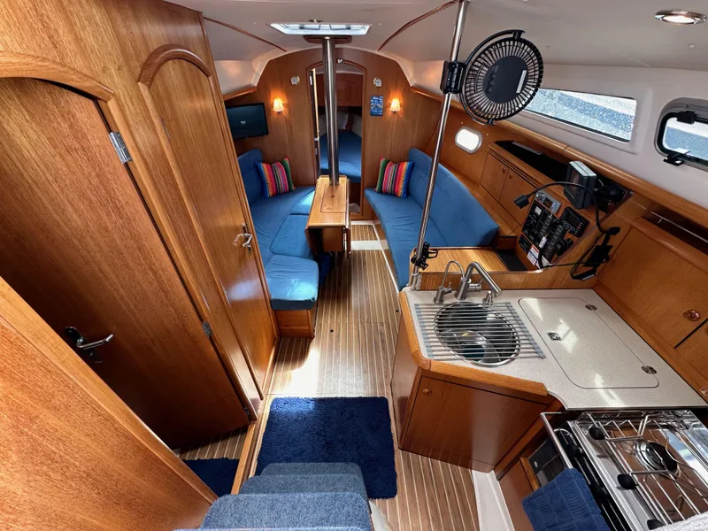 Slide: The Image of Interior of 2003 Jeanneau Sun Odyssey 32 sailboat with wood finish and blue seating. - 43