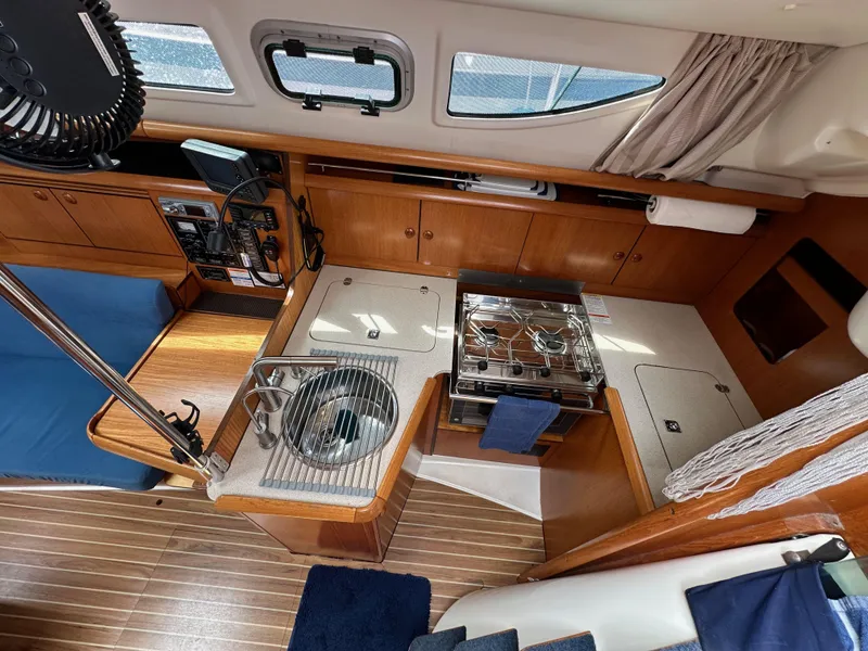 Slide: The Image of Interior of 2003 Jeanneau Sun Odyssey 32 sailboat with kitchen and seating area. - 44