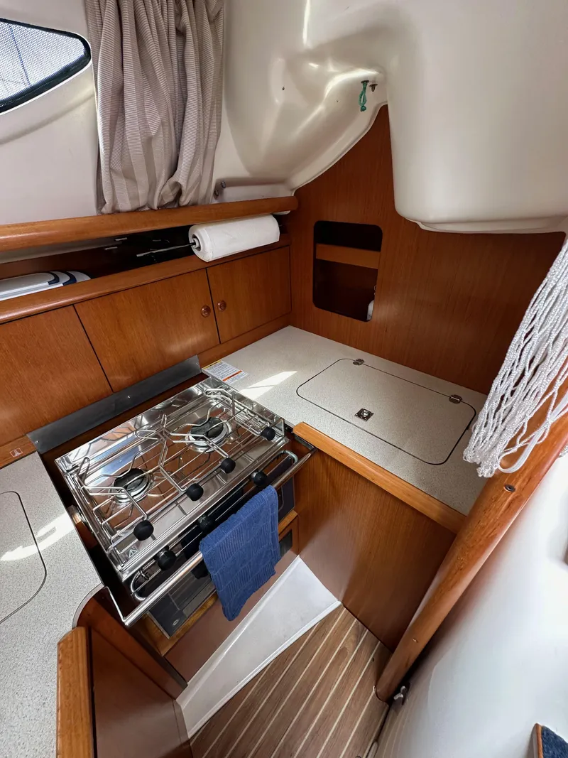 Slide: The Image of 2003 Jeanneau Sun Odyssey 32 yacht interior with compact kitchen and stove. - 46