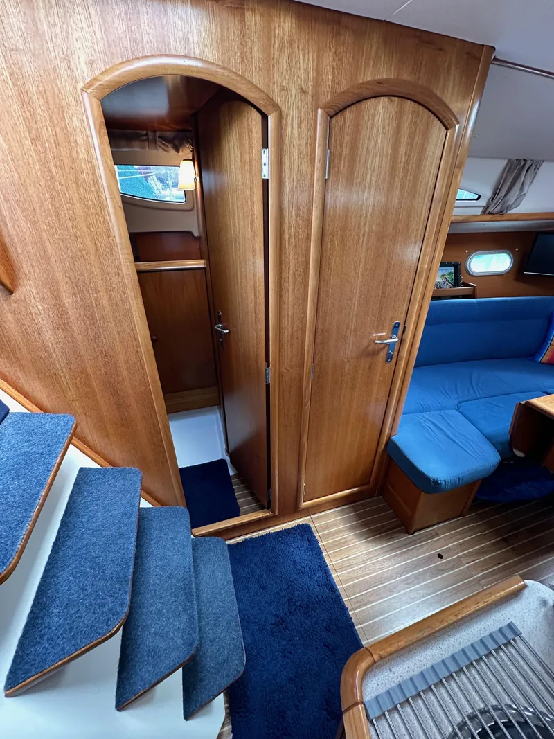 Slide: The Image of Interior of 2003 Jeanneau Sun Odyssey 32 sailboat with wooden finish and blue upholstery. - 51